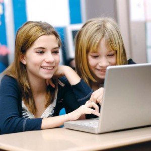 Two young girls working on a laptop in the classroom - Ziarul National