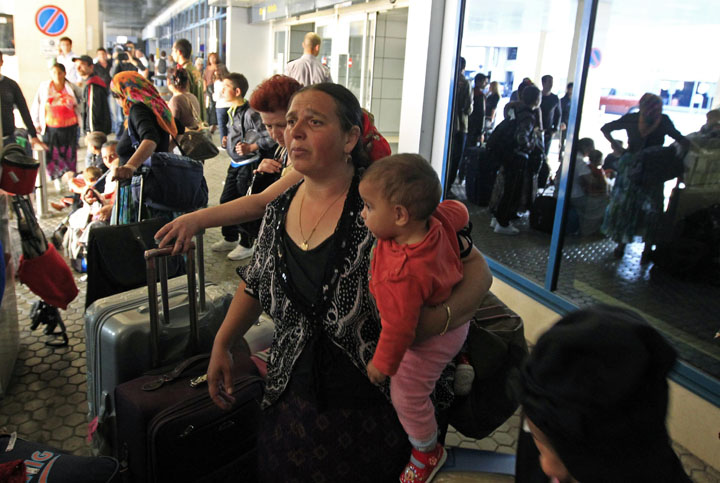 Roma families board a bus to travel to the railway station after around 200 Roma people repatriated from France arrived at Bucharest airport - Ziarul National
