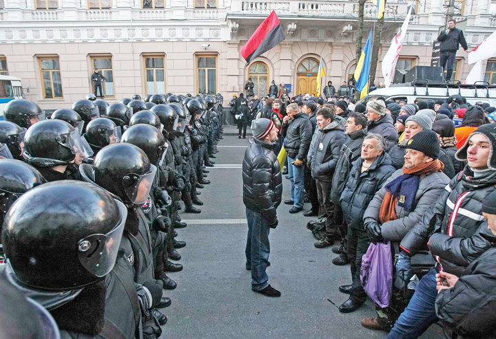 Police stand guard in front of protesters during a demonstration in support of EU integration in front of the Parliament building in Kiev - Ziarul National
