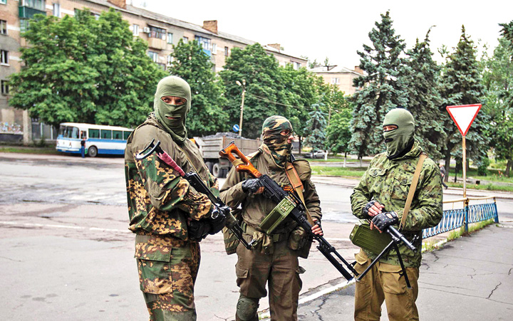 Armed pro-Russian separatists look on at a town center in Snizhnye in eastern Ukraine - Ziarul National
