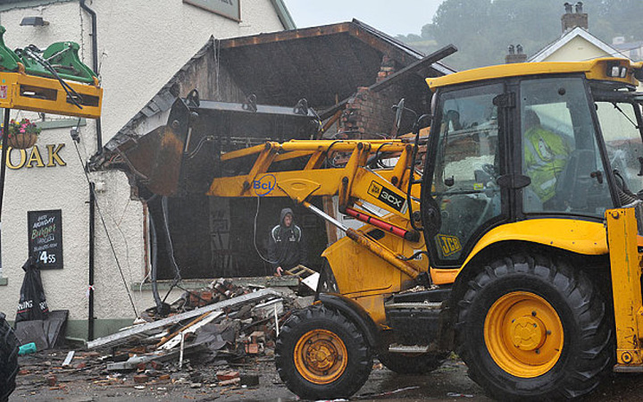Un afacerist galez s-a urcat intr-un excavator si a distrus un pub. Culmea, localul era al lui!