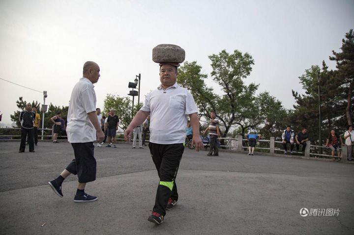 Merge de patru ani cu o piatra de 40 kg pe cap
