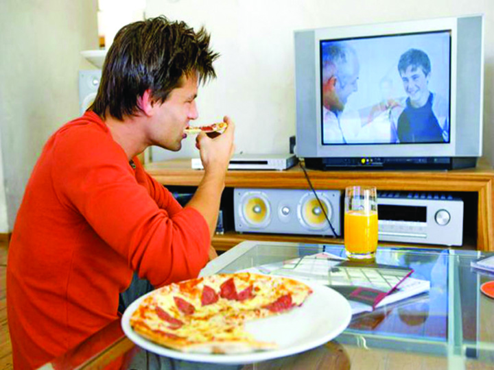 Romanii mananca lipiti de televizor