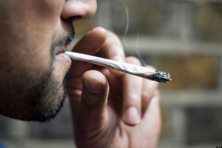 Close-up of an Asian man smoking marijuana joint - Ziarul National