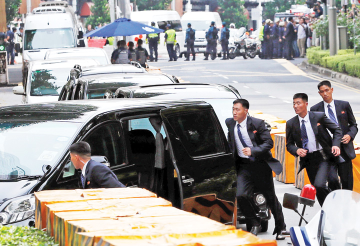 North Korean security personnel run next to a motorcade believed to be carrying North Korea's leader Kim Jong Un in Singapore - Ziarul National
