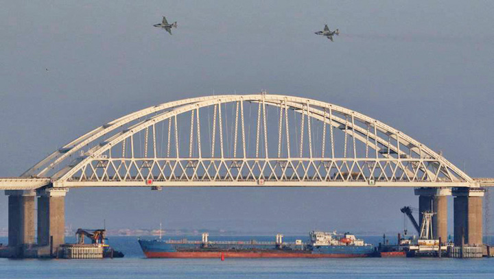 Russian jet fighters fly over a bridge connecting the Russian mainland with the Crimean Peninsula with a cargo ship beneath it after three Ukrainian navy vessels were stopped by Russia from entering the Sea of Azov via the Kerch Strait in the Black Sea - Ziarul National