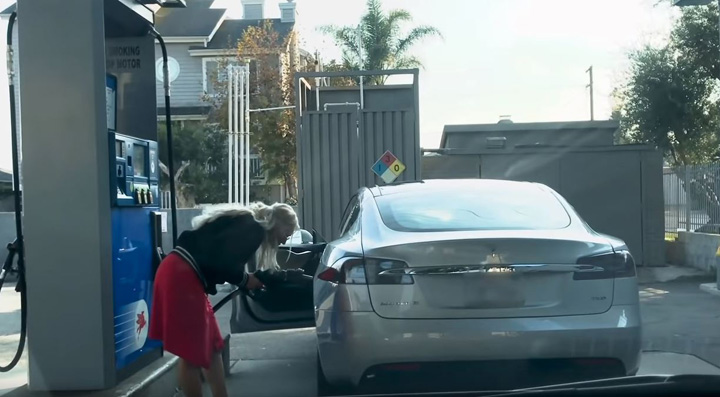 Blonda cu Tesla la benzinarie