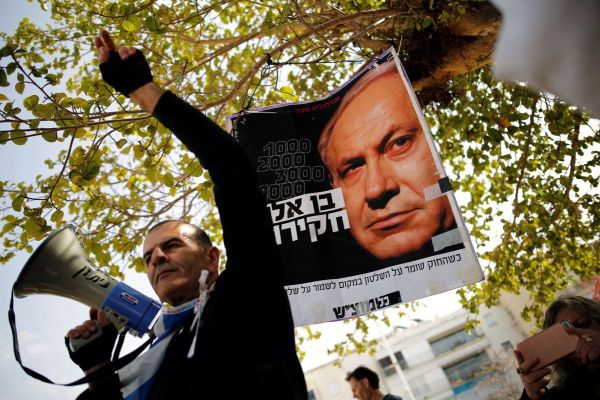 Protesters hold signs as they take part in a rally calling upon Israeli Prime Minister Benjamin Netanyahu to step down in Tel Aviv, Israel - Ziarul National