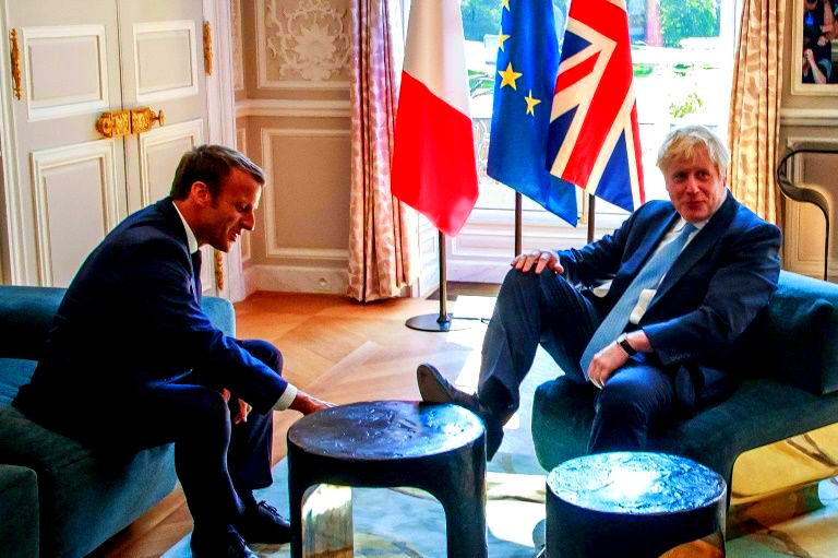 Boris Johnson s-a urcat cu picioarele pe masă la Palatul Elysee sub privirile lui Macron