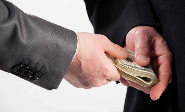 20935047 - businessman giving a bribe, neutral background - Ziarul National