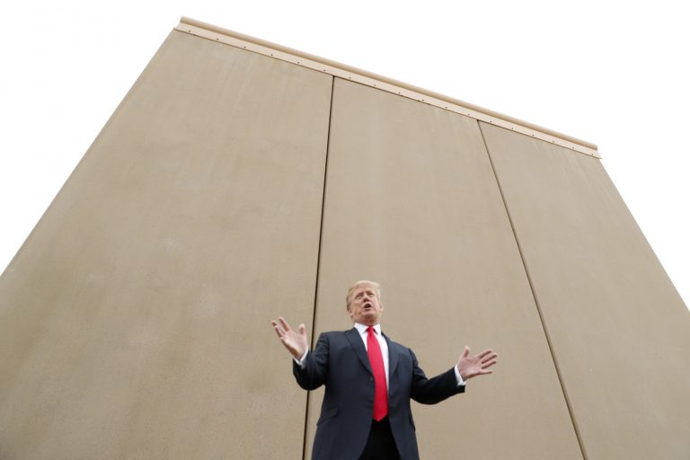 Trump, cu fața la zid, mâinile sus și picioarele îndepărtate