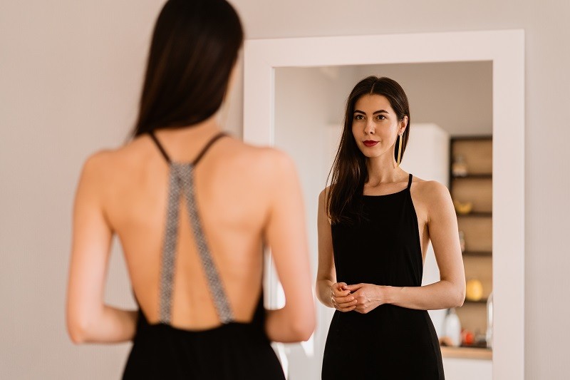 Lady wears beautiful black dress looking into the mirror - Ziarul National