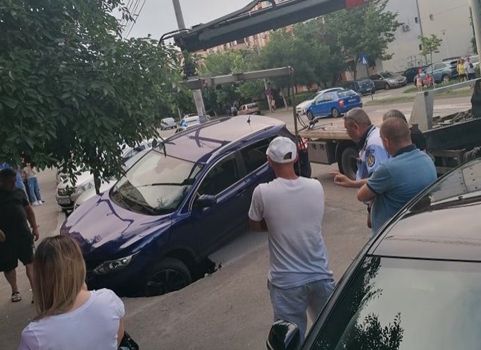 S-a crăpat asfaltul! Mașină blocată într-un crater apărut pe o stradă din Craiova – VIDEO