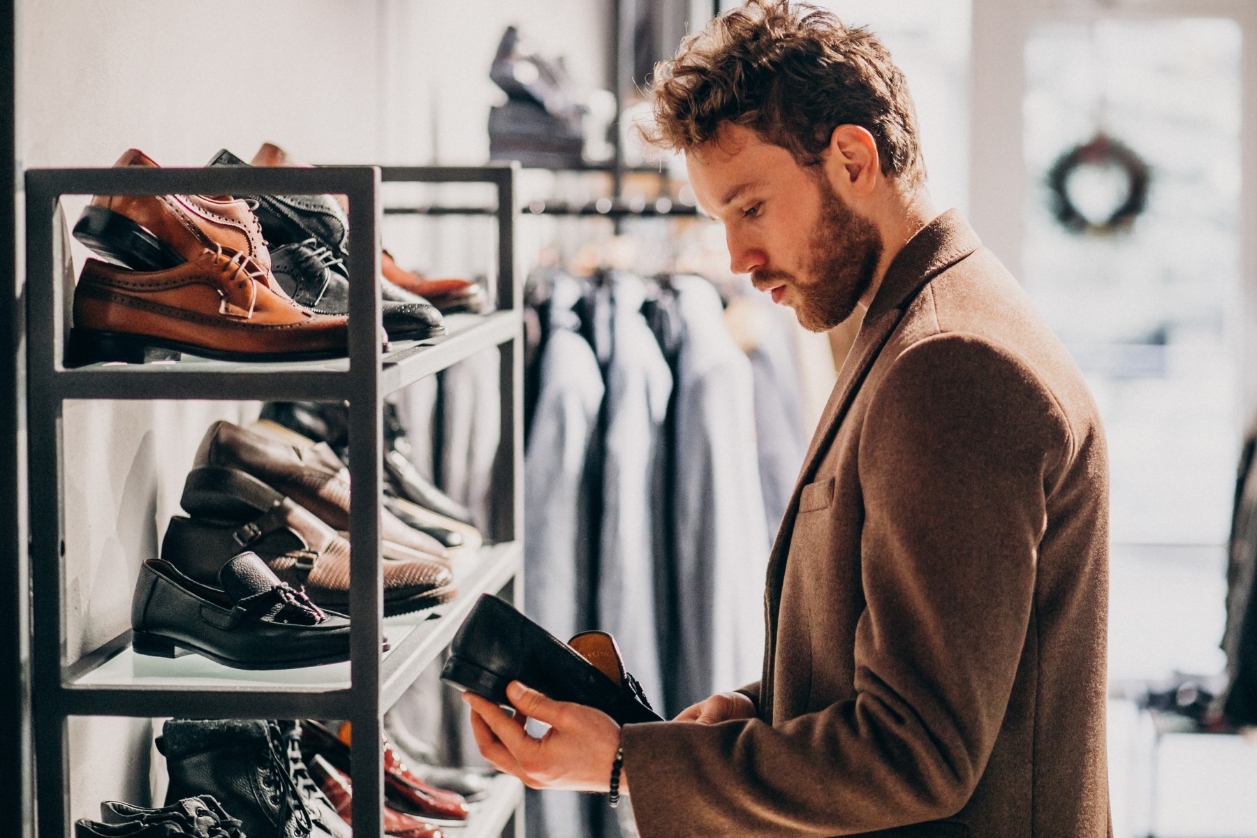 Young handsome man choosing shoes at a shop - Ziarul National