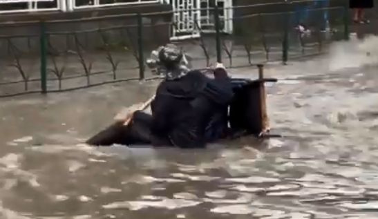 Imagini impresionante. Momentul în care doi oameni sar în ajutorul unui bărbat în scaun cu rotile, căzut pe o stradă inundată, în Tulcea – VIDEO